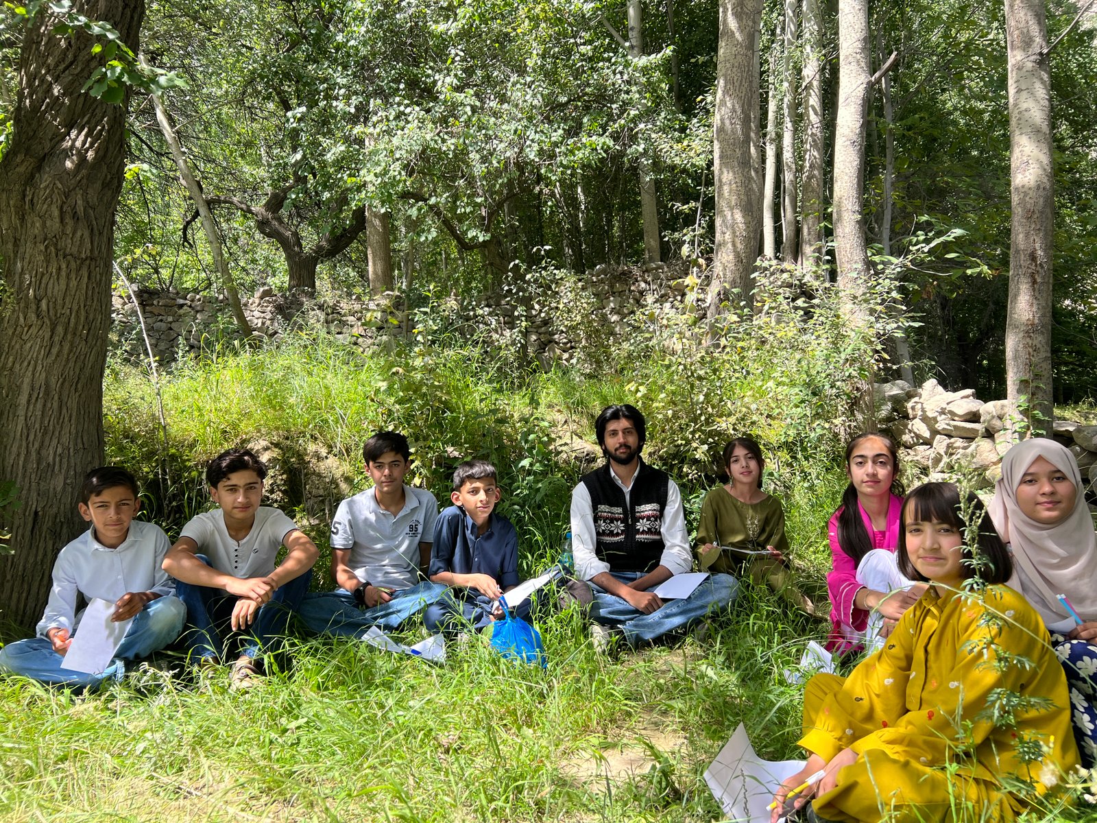 E4 Foundation students gathered outdoors during a class session in Hunza.